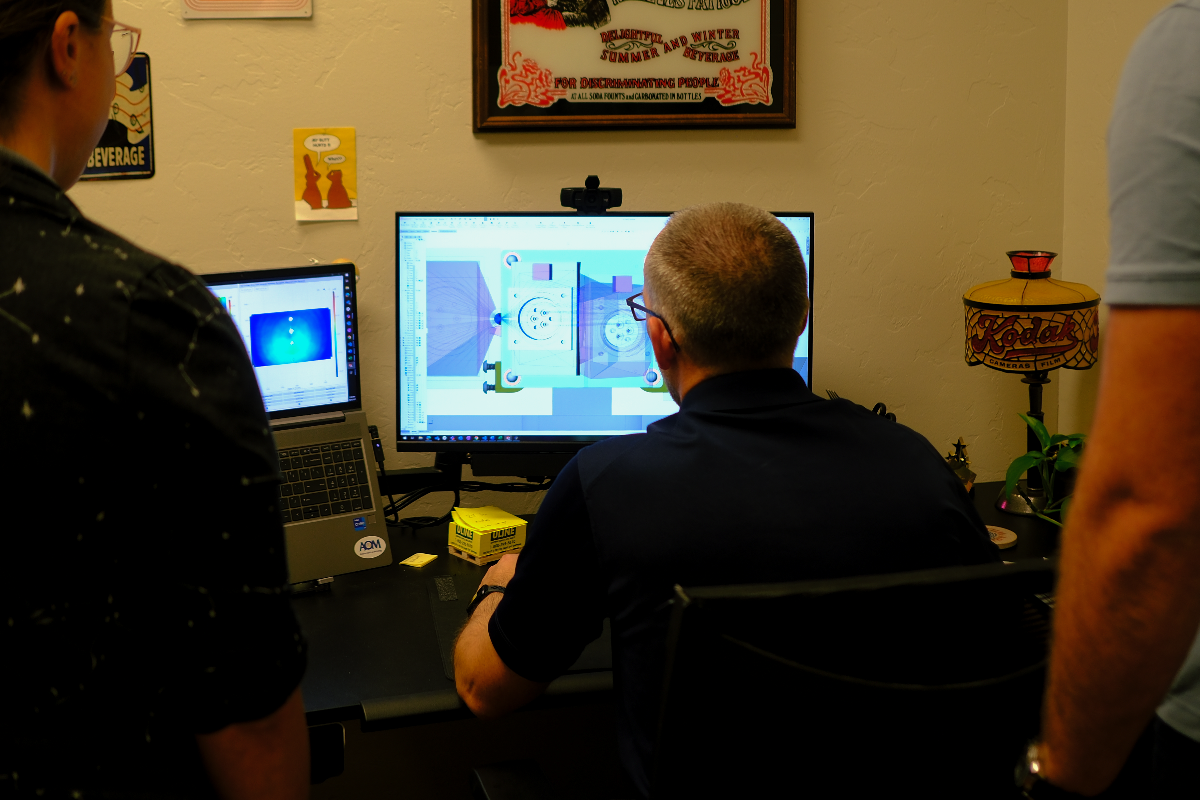 Engineers observe renderings of an optical metrology system on a computer screen