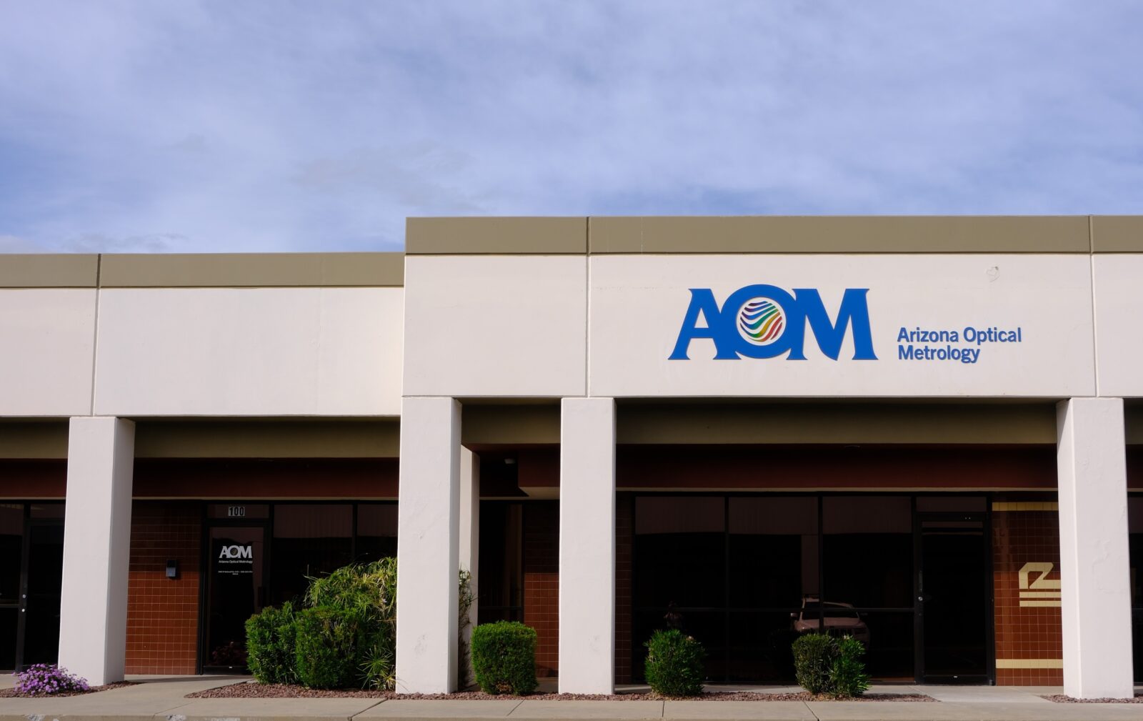 Exterior of new AOM office building with a metal sign of the logo